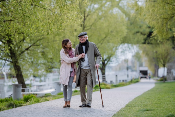 mujer paseando con una persona mayor en un parque